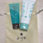 Two mint teal and white skincare tubes resting on a beige Yojiya bag with Kyoto logo visible.