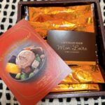 Box of orange-wrapped chocolates with a red Mon Loïre promo card in a brown gift box