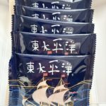 Five navy blue snack sachets stacked inside a box, each with white Chinese characters and a sailing-ship illustration on the bottom wrapper.