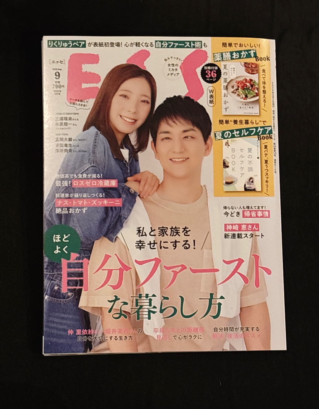 Smiling couple on the cover of a Japanese lifestyle magazine, woman leaning on man’s shoulder with bold pink title text.
