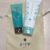 Two mint teal and white skincare tubes resting on a beige Yojiya bag with Kyoto logo visible.