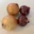 Four onions (two yellow, two red) arranged on a white surface for a cooking prep scene.