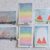 Six small Polaroid photos taped to a textured wall; left two show pastel sunset cityscapes and skies, cream borders around each image.