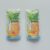 Two identical pineapple juice pouches with a pineapple illustration and blue gradient, placed on a light gray surface.